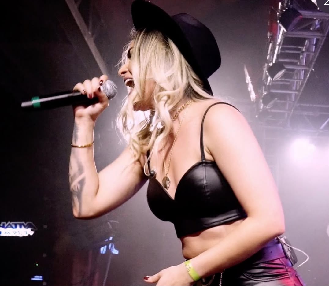 Vanessa Vaqueira de chapéu preto em grande performance no palco